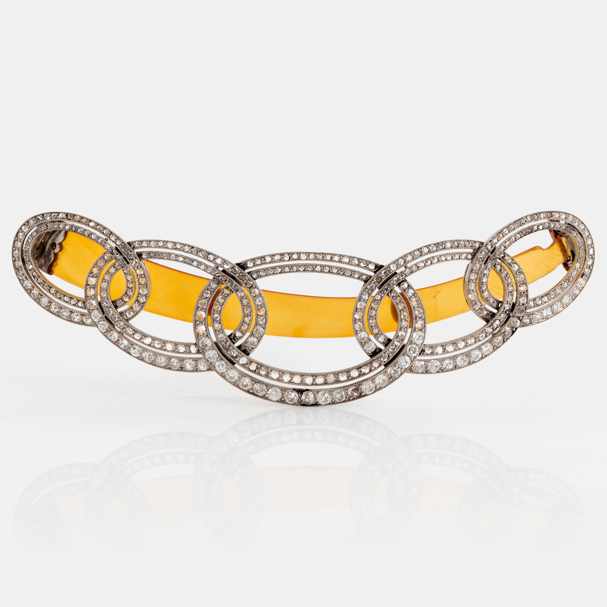 An Art Deco barrette/hairclip signed Cartier in platinum set with old- and rose-cut diamonds.