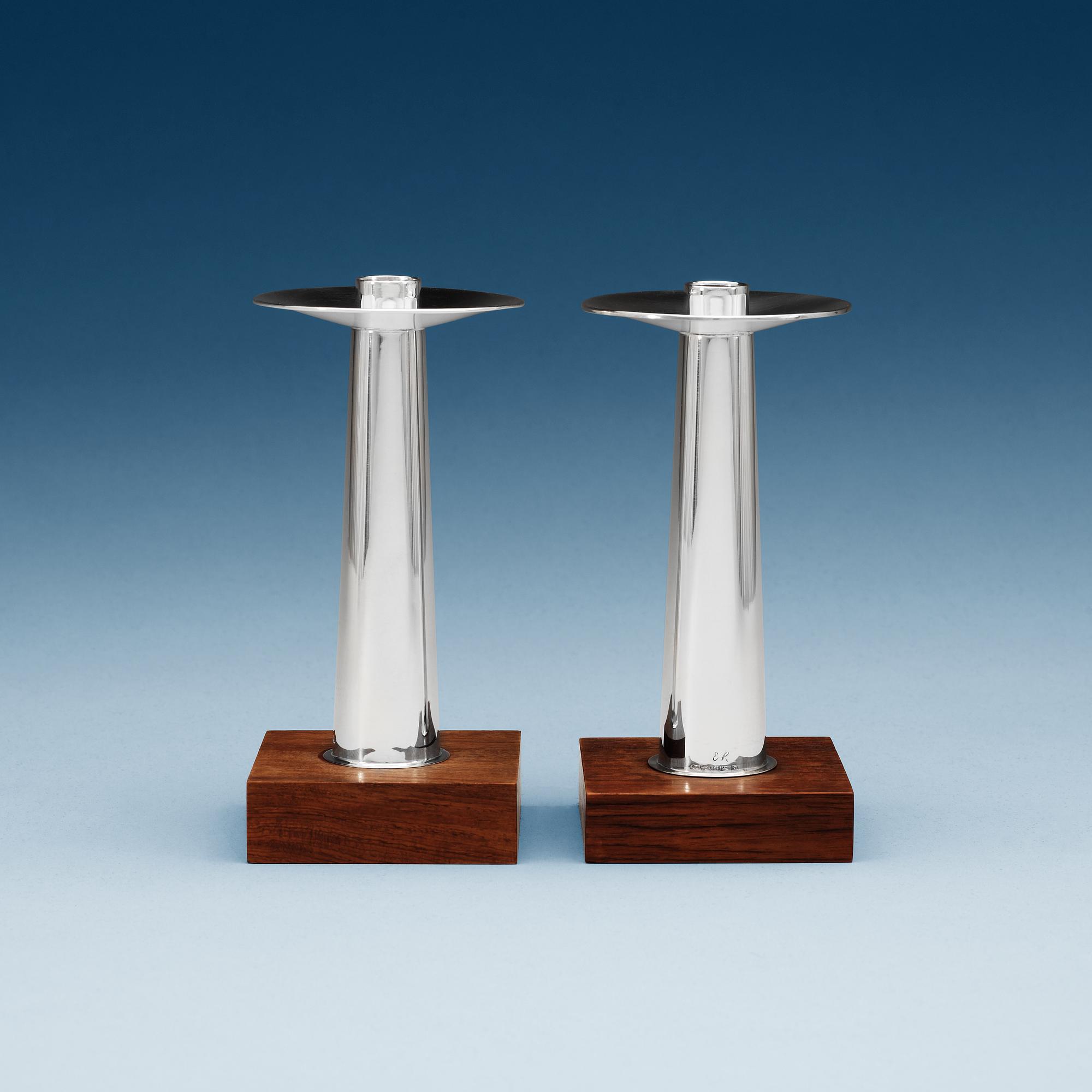 A pair of Finnish silver candlesticks on a teak base, Kultakeskus OY, Tavastehus, Finland 1963.