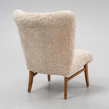 A mid 20th Century easy chair with sheepskin upholstery.