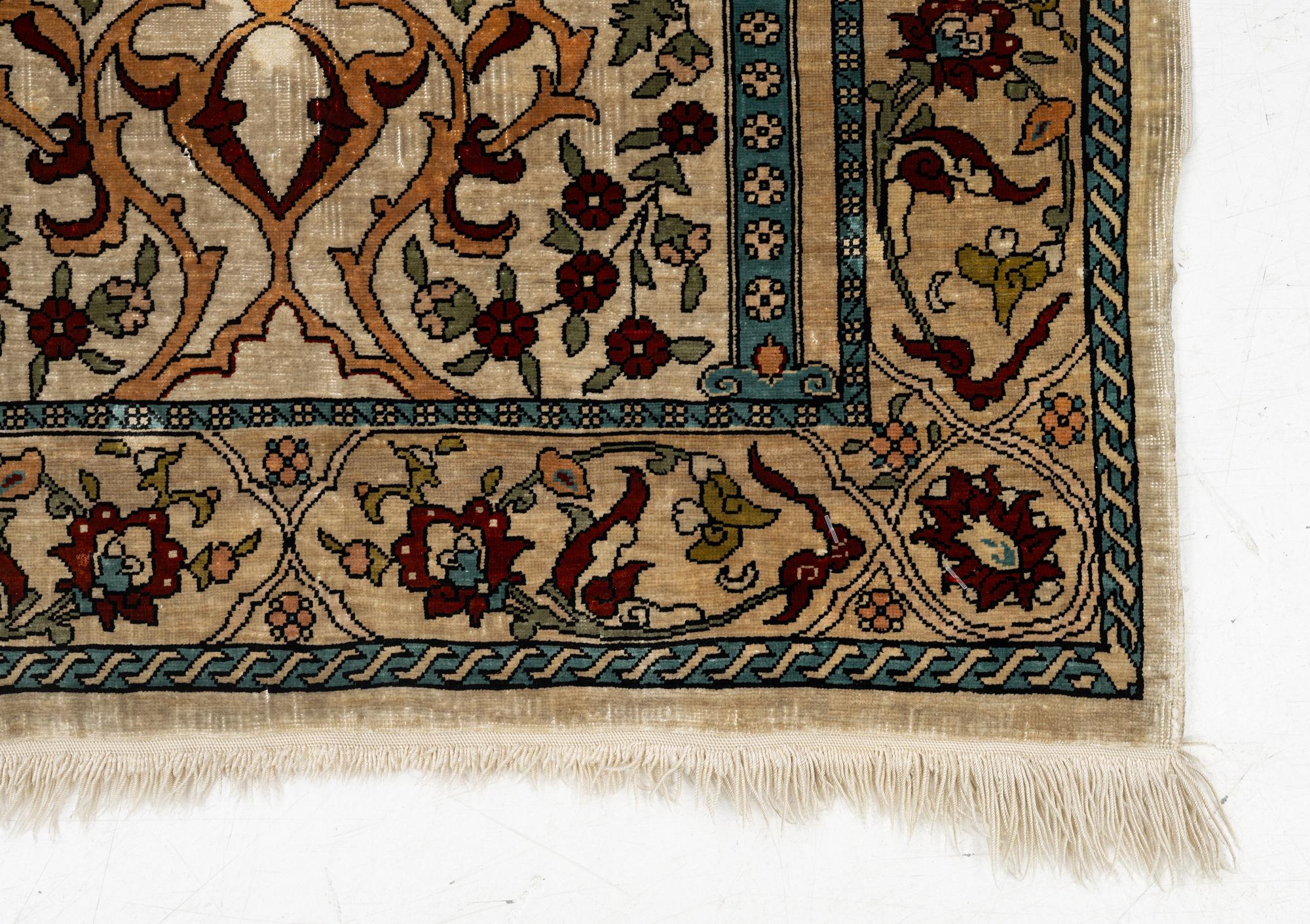 A Hereke silk rug, c. 73 x 52 cm.