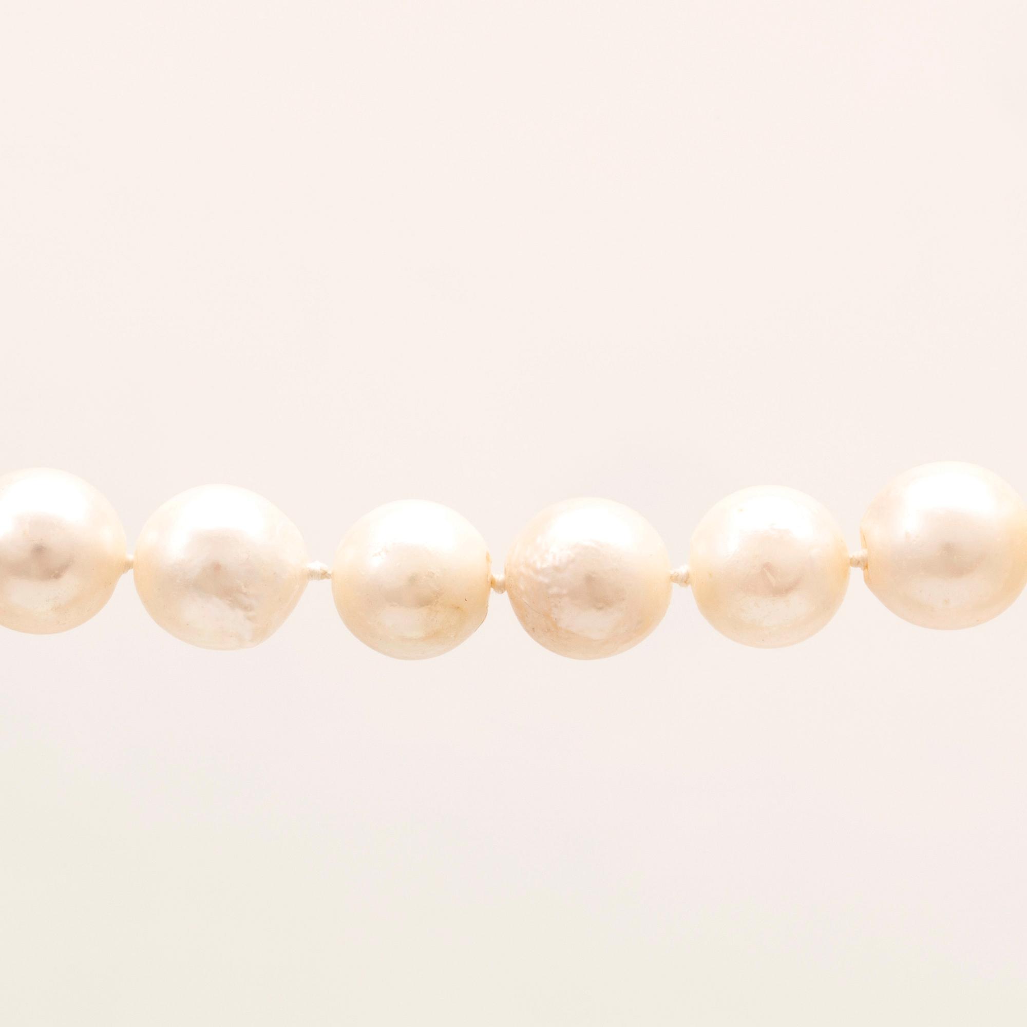 A necklace of cultured pearls, lock in 18K white and red gold set with a round brilliant cut diamond by Ole Lynggaard.