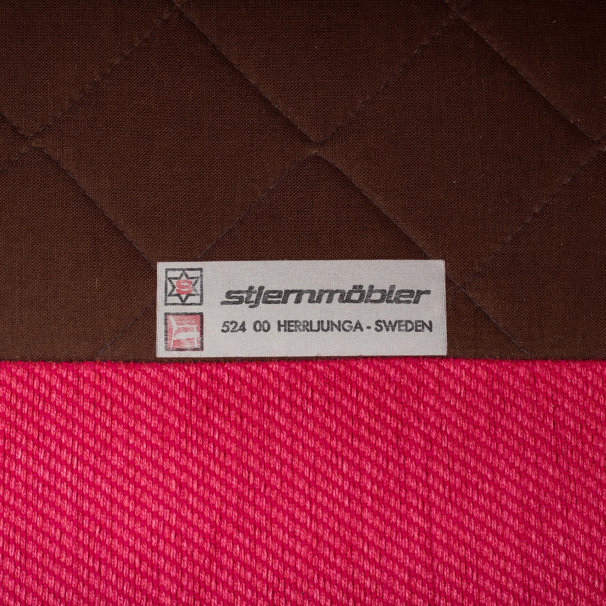 An 'Oxford' model no 3543 easy chair with stool by Ragnar Helsén for Firma Svenskt Tenn.