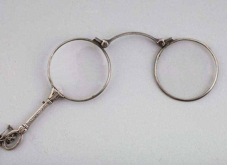 LORGNETTE MED KEDJA, silver, omkring år 1900.