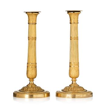 120. A pair of French Empire ormolu candlesticks, early 19th century.