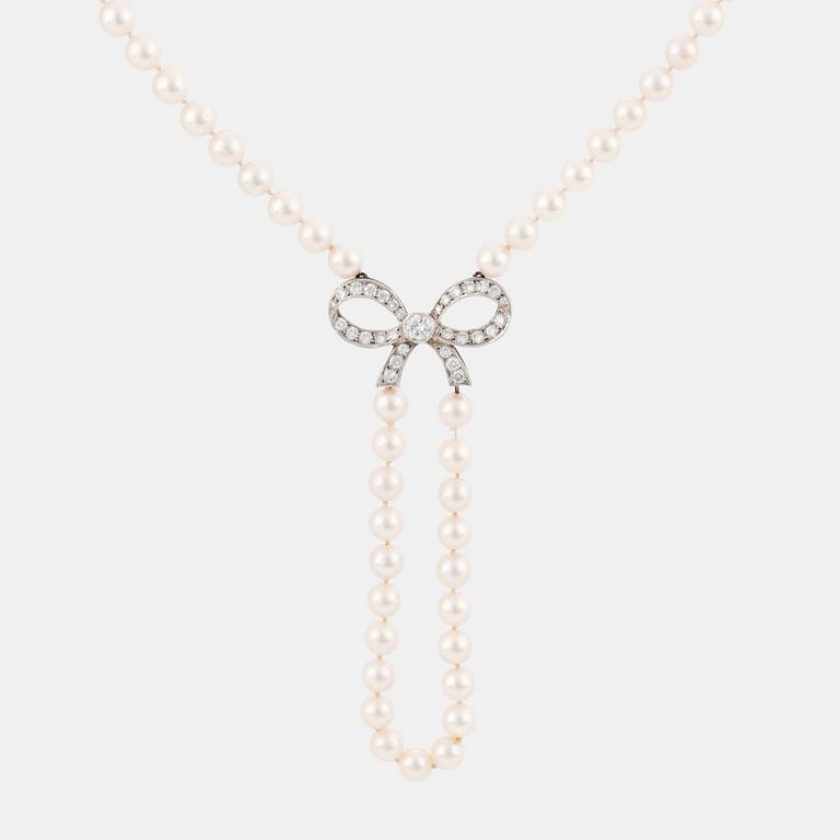 A cultured pearl necklace with a 14K white gold bow pendant set with round brillliant-cut diamonds.