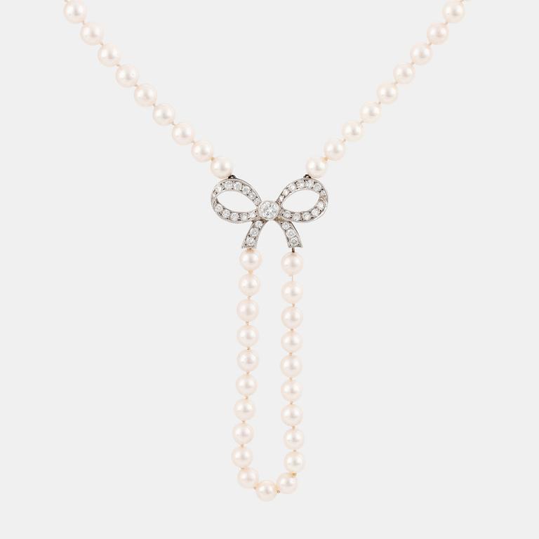 A cultured pearl necklace with a 14K white gold bow pendant set with round brillliant-cut diamonds.