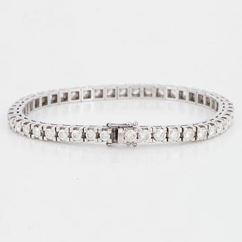 An 18K white gold tennisbraclet set with round brilliant-cut diamonds.