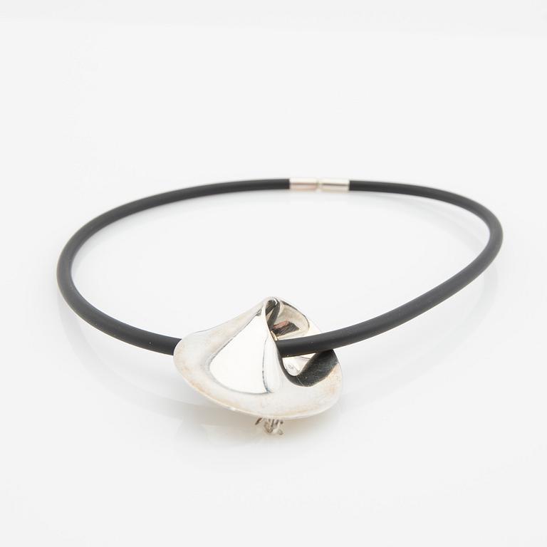 Vivianna Torun Bülow-Hübe, Hängsmycke/brosch, "Möbius", samt gummicollier, för Georg Jensen, Danmark.