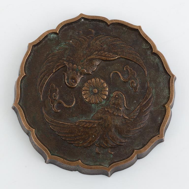 A bronze mirrorshaped paperweight, Japan 195. Decorated with Chrysantemum and birds.