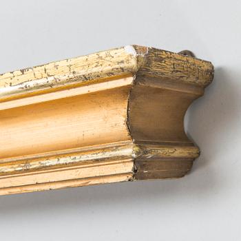 A curtain rod in leaves gilded wood and a pair of curtain holders in gilt metall.