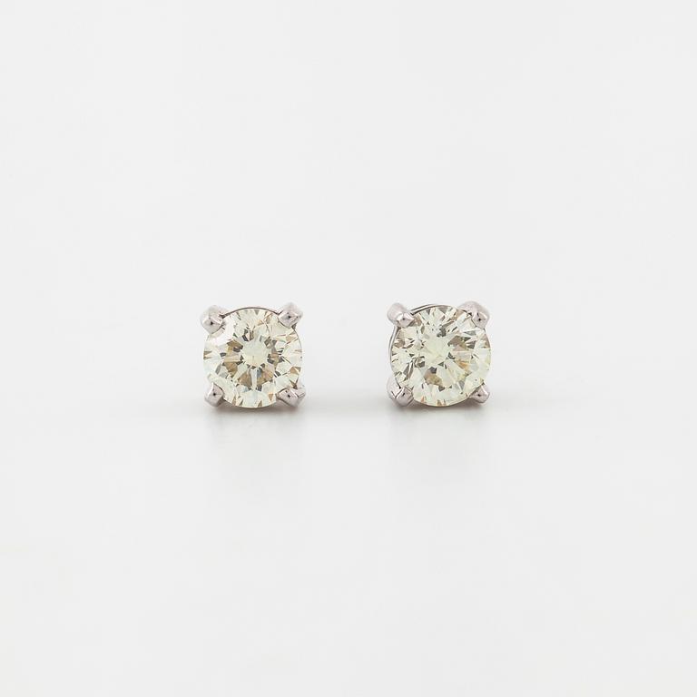 A pair of brilliant cut diamond earrings.