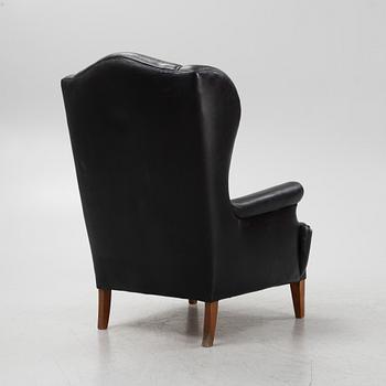A leather upholstered wingback chair, 20th Century.
