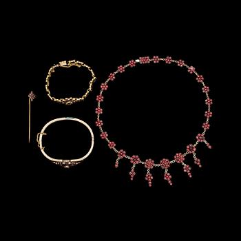 GARNITYR, 4 delar. Gulmetall besatt med granater. Tidigt 1900-tal.