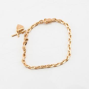 Bracelet with rounded anchor link in 18K gold with charms.