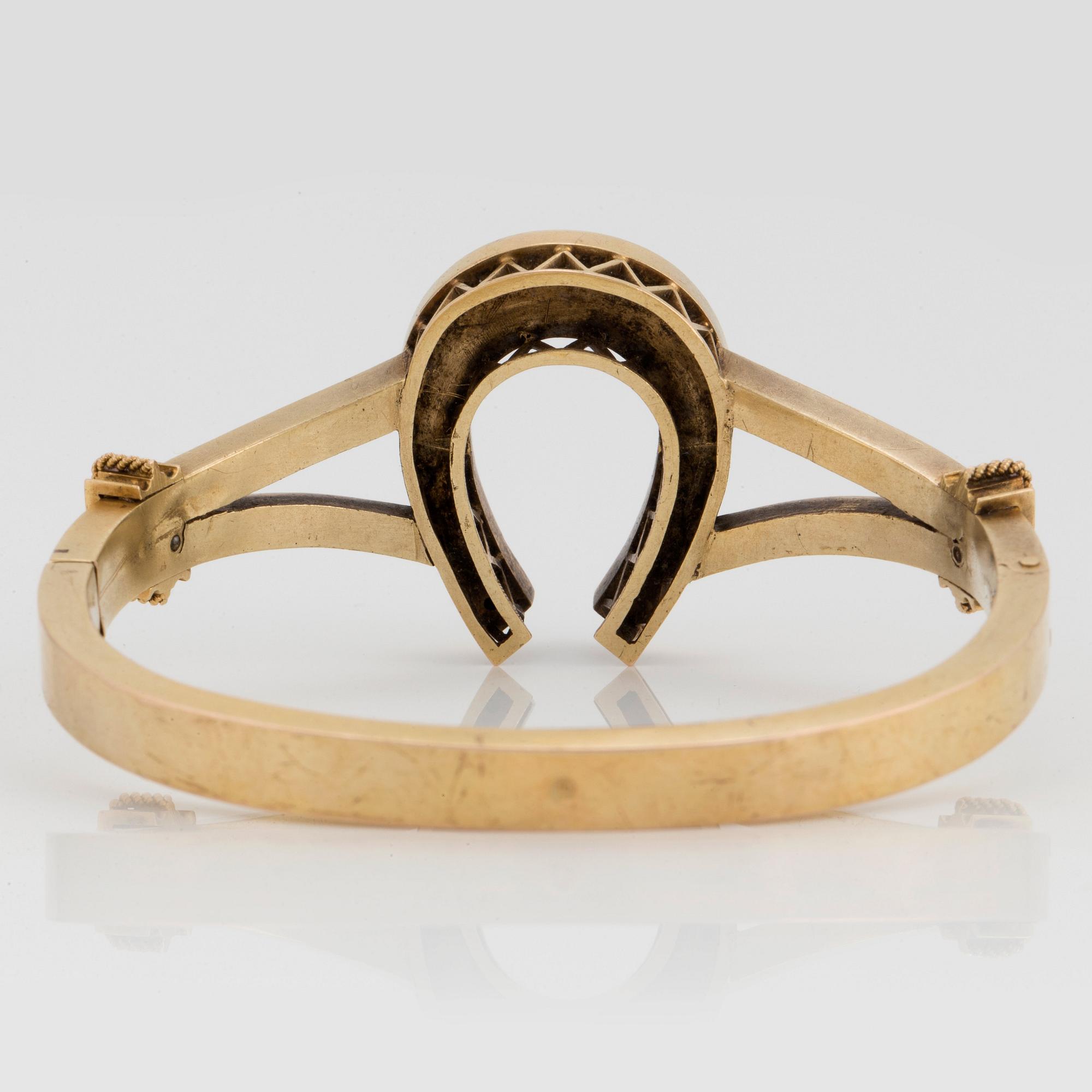 A 14K gold horse shoe bangle set with turquoises.