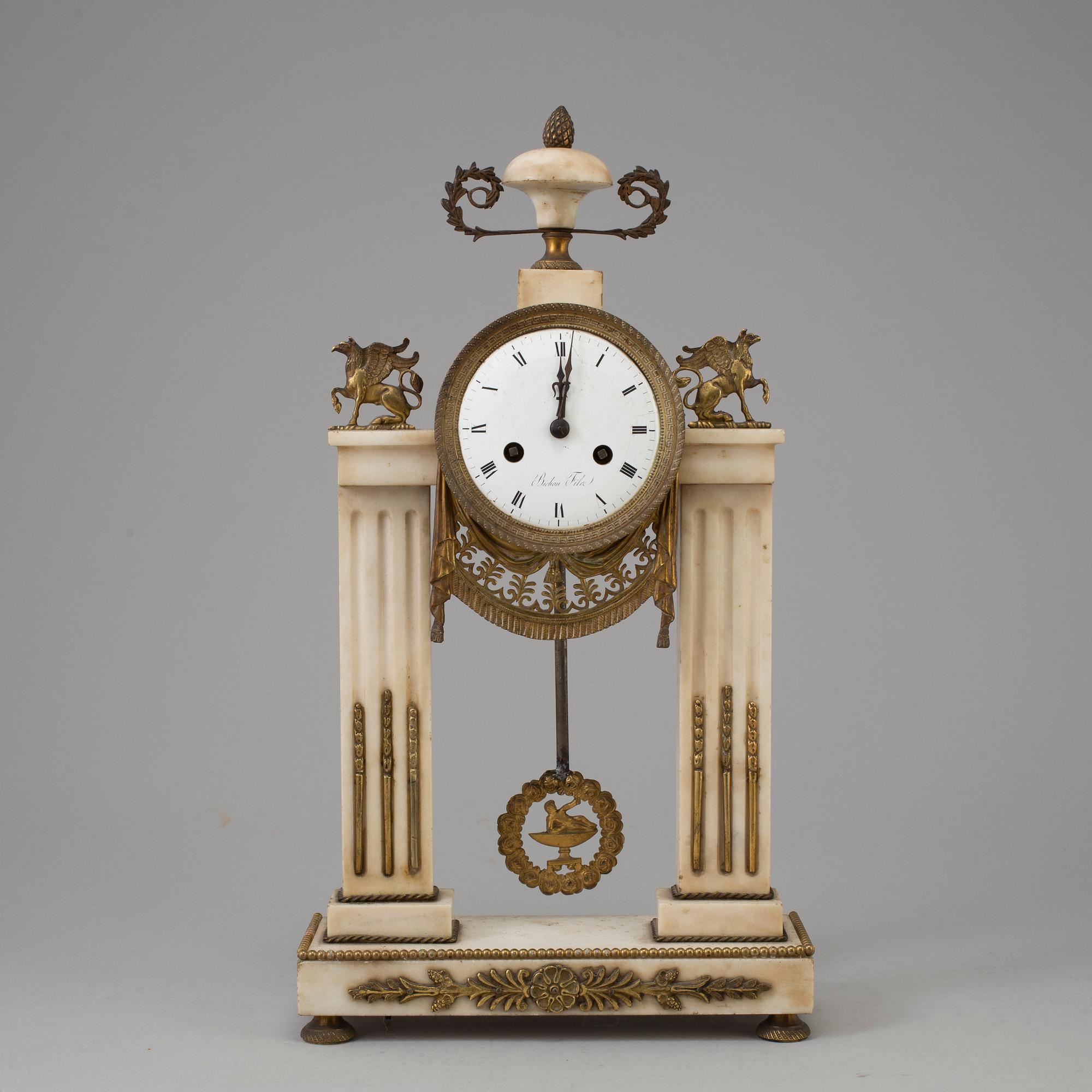 A FRENCH EMPIRE MARBLE AND BRASS MANTEL CLOCK, first half of the 19th century.