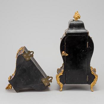 A Louis XV-style mantle clock with console base.