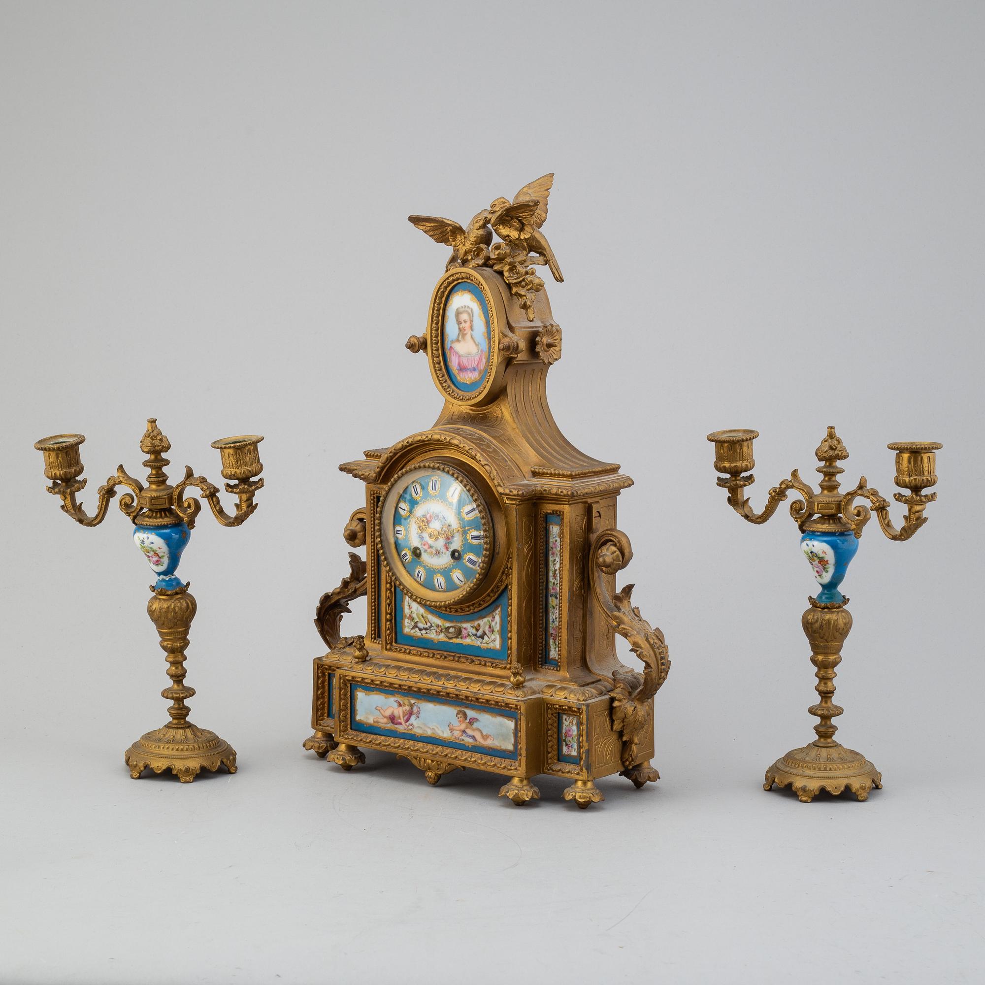 A table clock and two candelabras from the late 19th century.