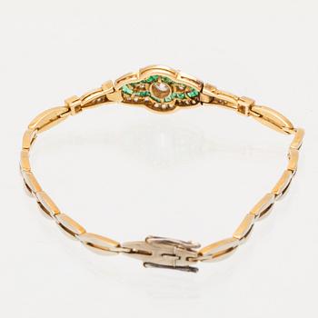 An 18K white and red gold bracelet set with emeralds between rose cut and old cut diamonds.