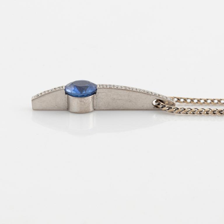 An 18K white gold necklace with a faceted sapphire and brilliant cut diamonds.