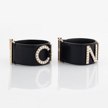 Chanel, a pair of black leather and rhinestone bracelets.