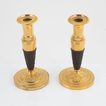 A pair of French Empire gilt and patinated bronze candlesticks, circa 1820's.