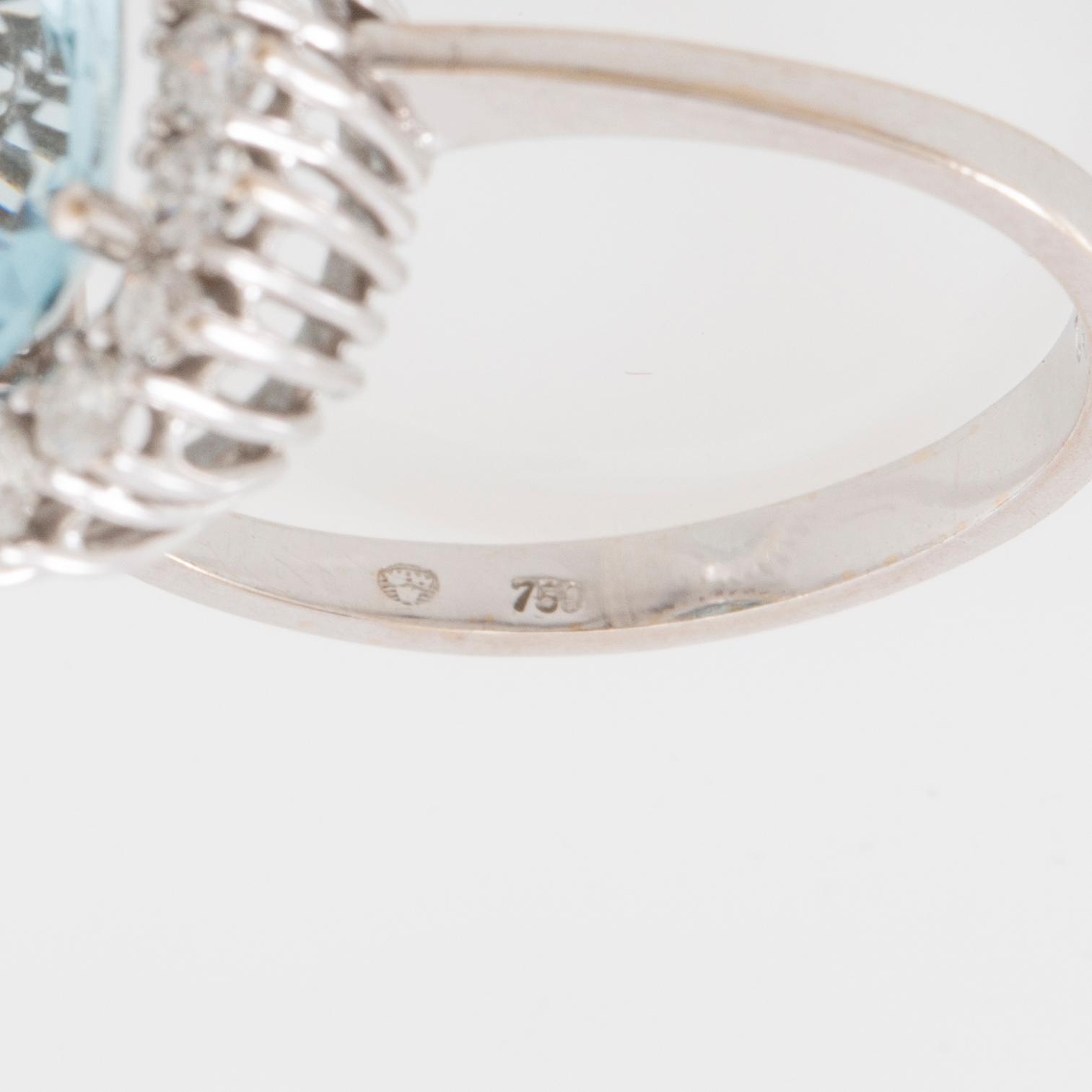 Ring 18K white gold set with an oval faceted aquamarine and round brilliant-cut diamonds.