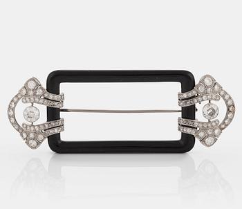 1038. A Janesich Art Deco brooch in onyx and platinum set with old- and eight-cut diamonds.