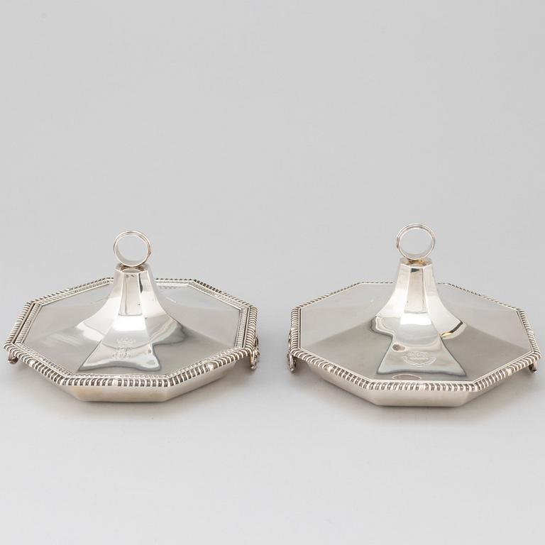 A matched pair of English silver dishes and covers, marked London 1910 and 1912.