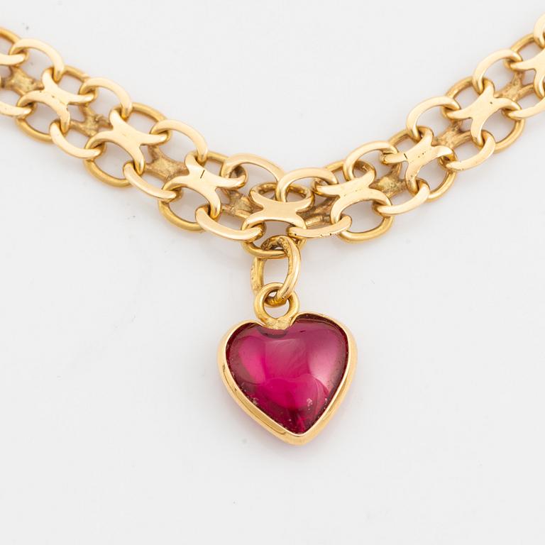 18K gold necklace with synthetic red stone heart charm.