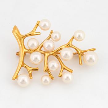 An 18K gold brooch se with cultured pearls.