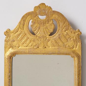 A matched pair of rococo giltwood one-branch girandole mirrors, Stockholm, late 18th century.