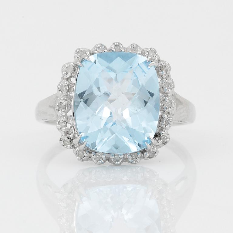 RING, 18K vitguld med chequerslipad blå topas, ca 5,23 ct, diamanter tot ca 0,20 ct. Vikt ca 4,17 g.