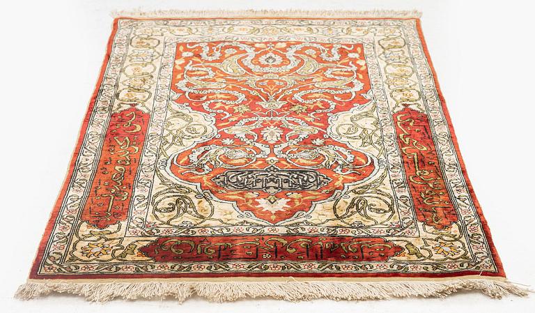 A silk and metal Hereke rug, c. 86 x 52 cm.