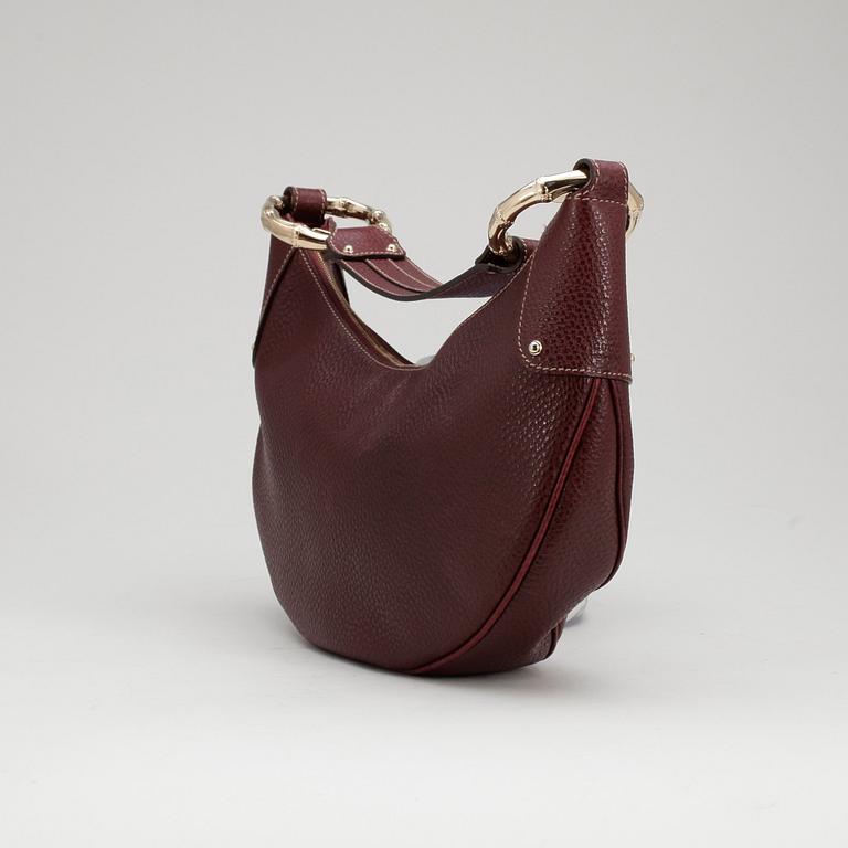 GUCCI, a dark burgundy red shoulder bag.