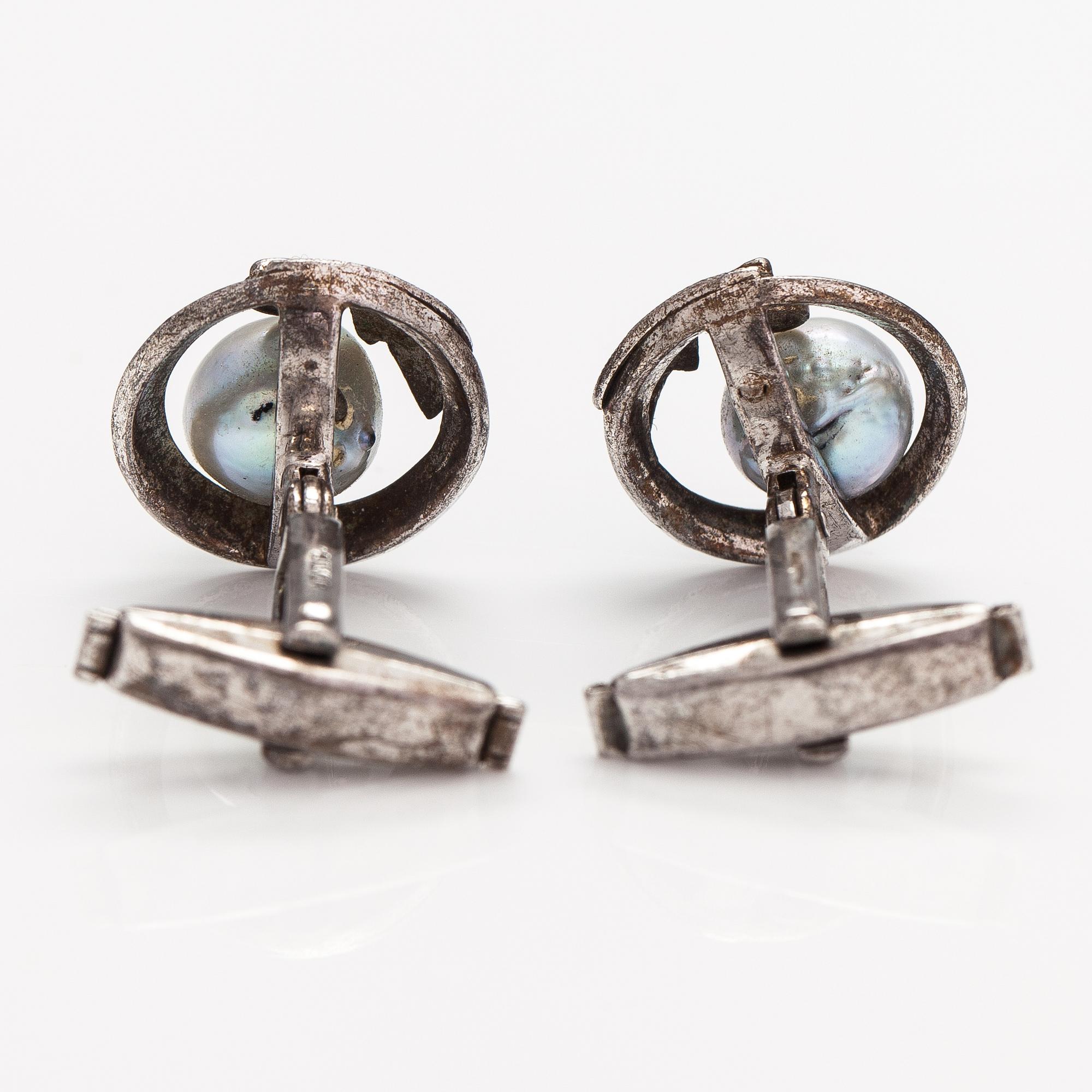 A pair of silver cufflinks with cultured baroque/Akoya pearls.