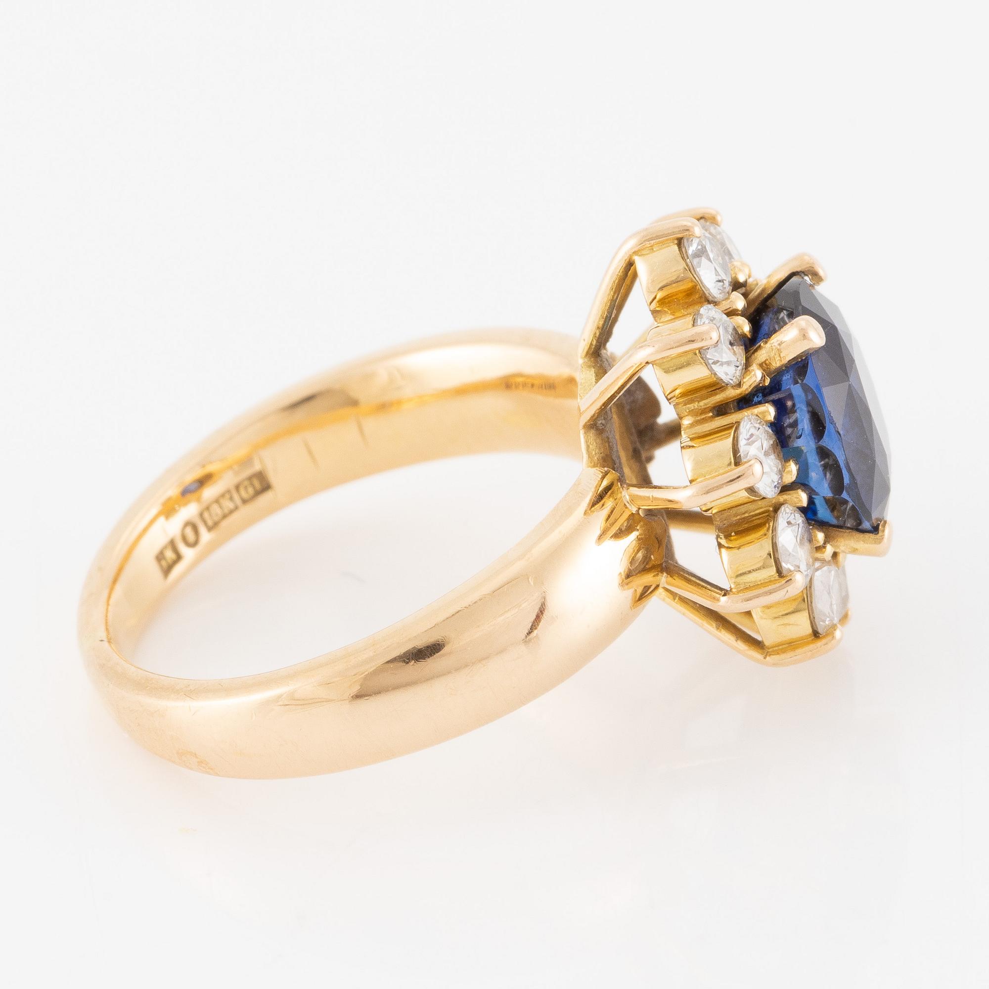 Ring 18K guld med en fasettslipad safir och runda briljantslipade diamanter.