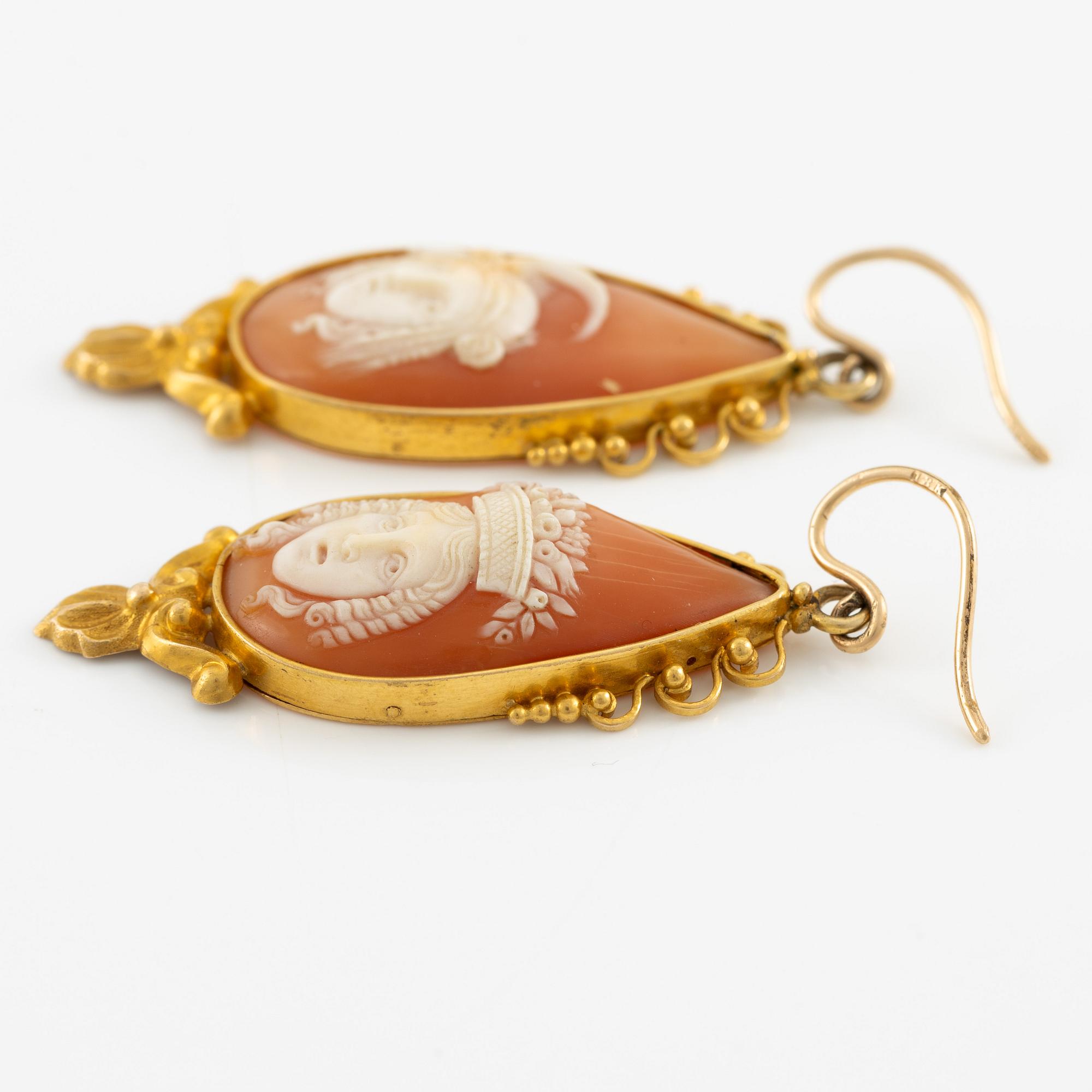 A pair of earrings in 18K gold with shell cameos.