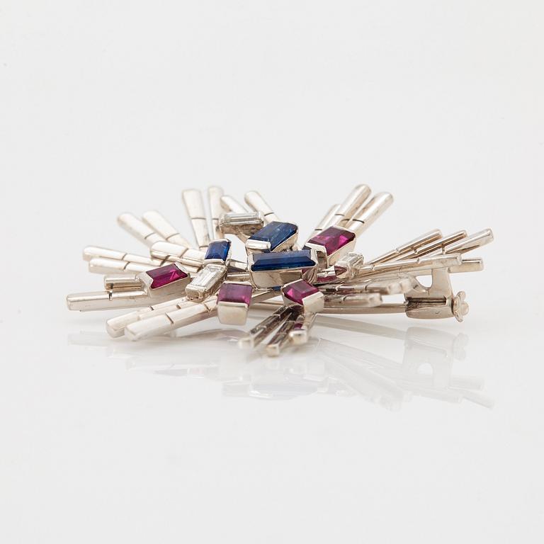 A WA Bolin brooch in 18K white gold set with baguette-cut diamonds, sapphires and rubies.