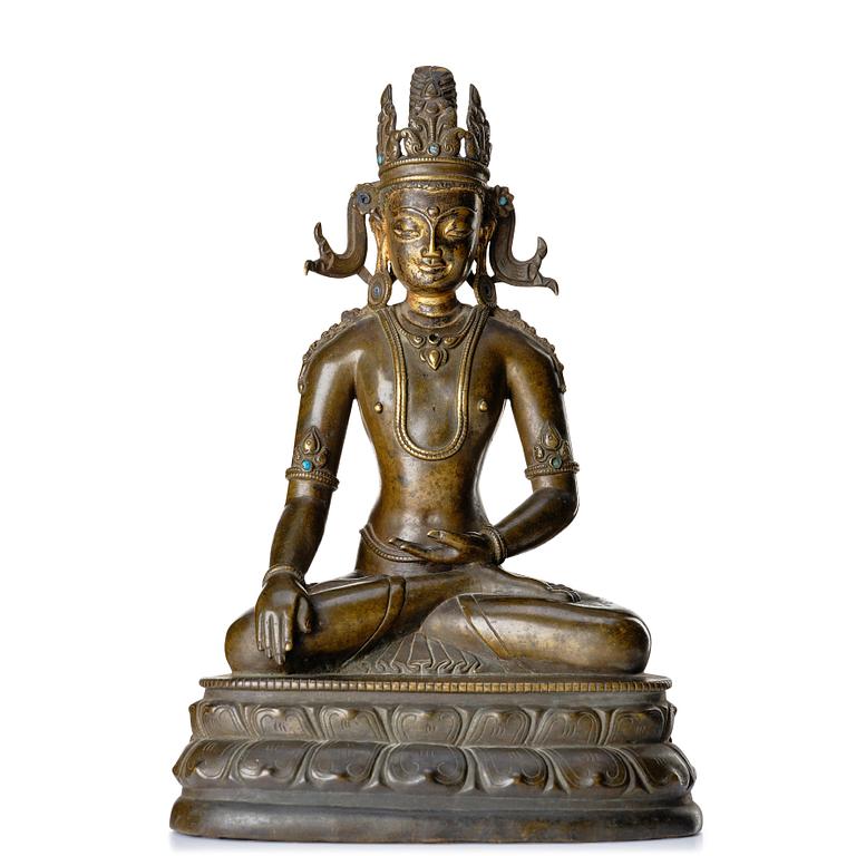 A bronze figure of a crowned buddha, Tibet, 14th Century.