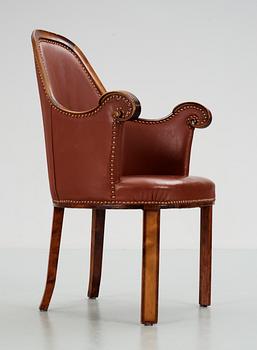 A Swedish easy chair in stained birch, upholstered in artificial leather, by NK, Nordiska Kompaniet, 1910's-20's.