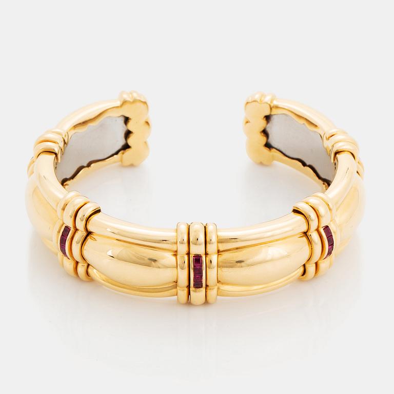 An 18K gold bracelet set with step-cut rubies.