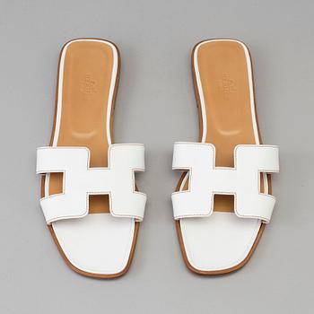 A pair of white leather shoes by Hermès.
