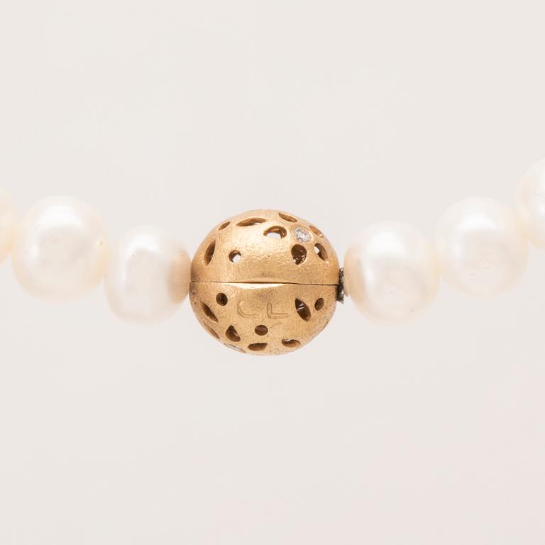 An 18K gold "Lace" lock by Ole Lynggaard set with round brilliant cut diamonds, necklace of cultured freshwater pearls.