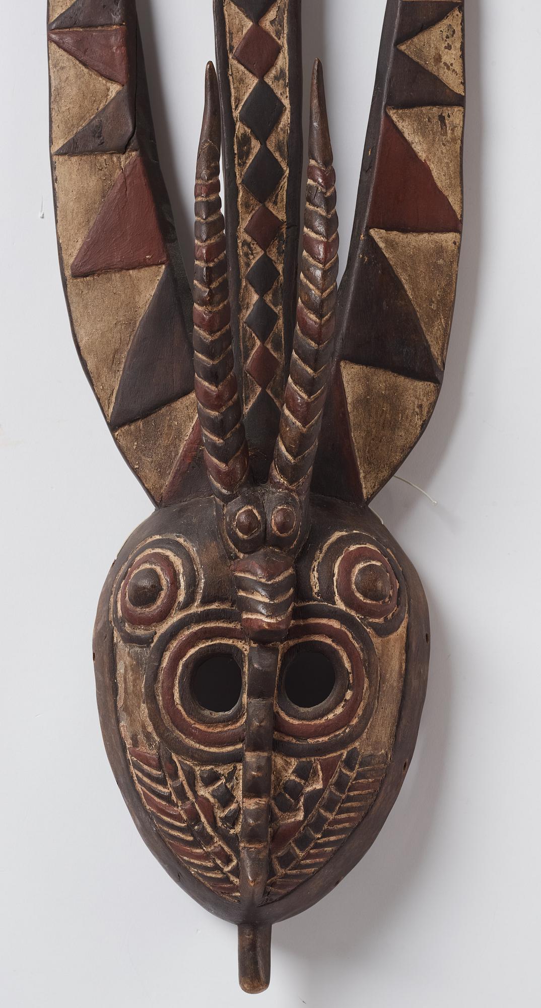 A sculptue and two masks reportedly from The Ivory coast, from the second half of the 20:th century.