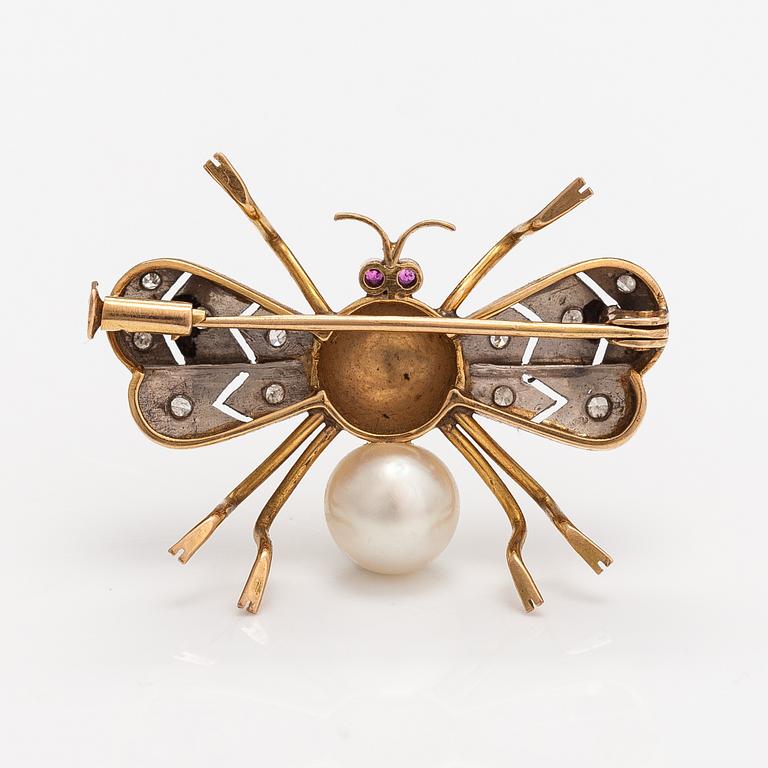 A 15-17K gold brooch with rubies, a cultured pearl and diamonds ca. 0.10 ct in total.