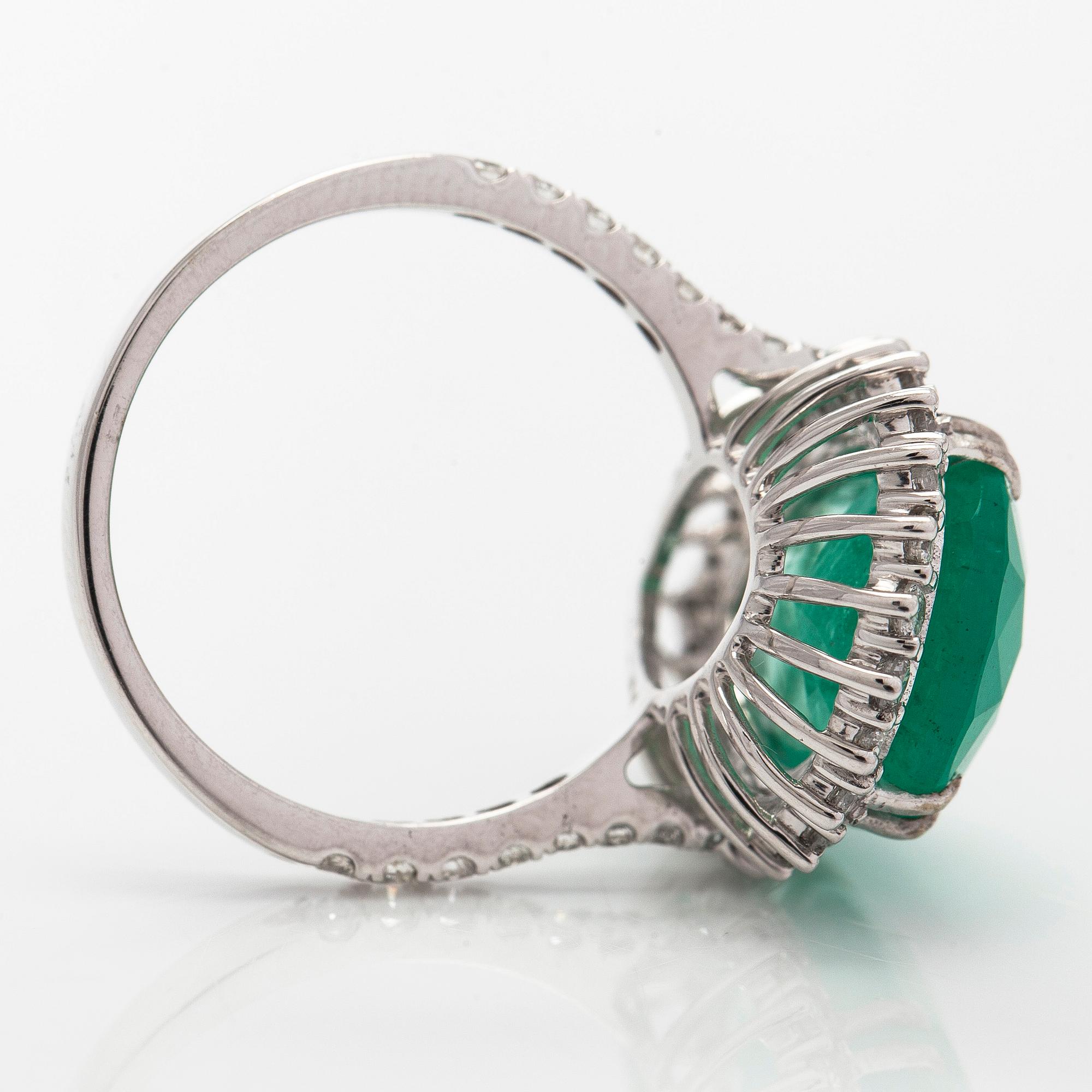 A 14K white gold ring, with a pear-cut  emerald ca. 7.72 ct and diamonds.