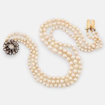 885. A three strand cultured pearl necklace with a clasp in 18K gold and silver set with rose- and old-cut diamonds.