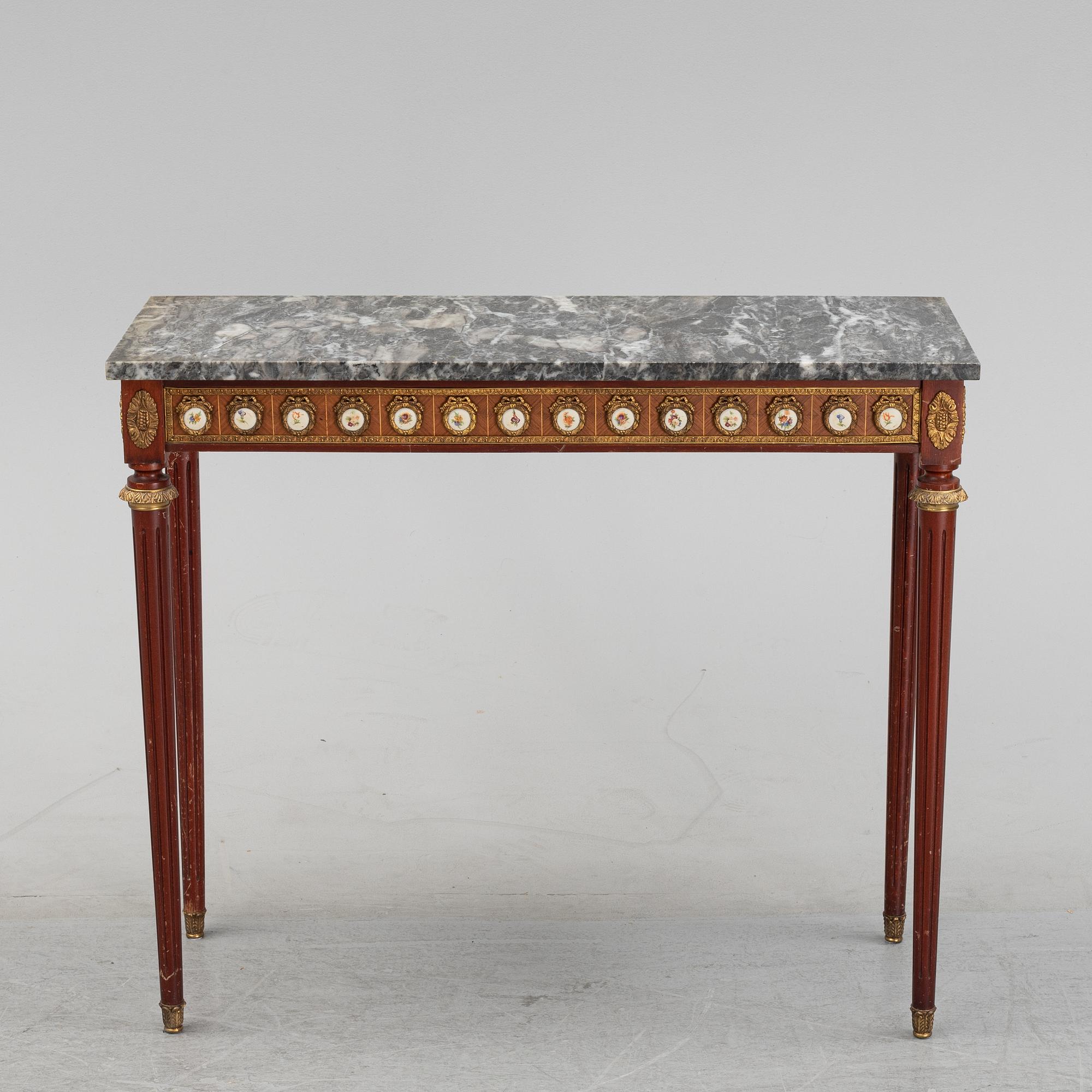 A Louis XVI style console table with a marble top.