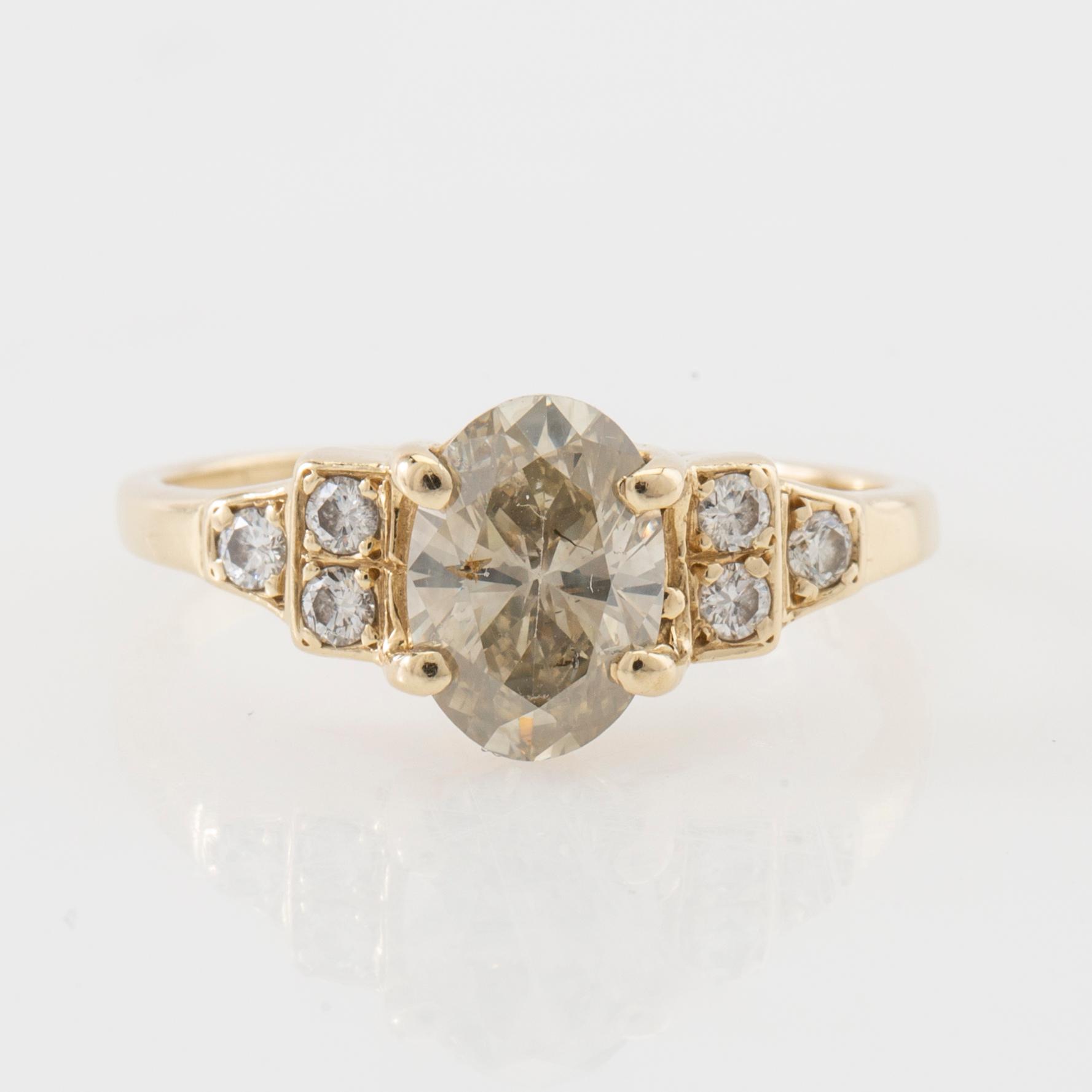 Ring 14K gold with an oval faceted diamond approximately 1.23 ct and round brilliant-cut diamonds.
